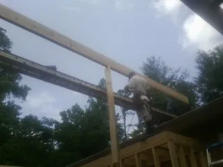 Carpenter setting a ridge beam over a new addition frame — Ice Dam Removal by Roofing Brothers in Twin Peaks
