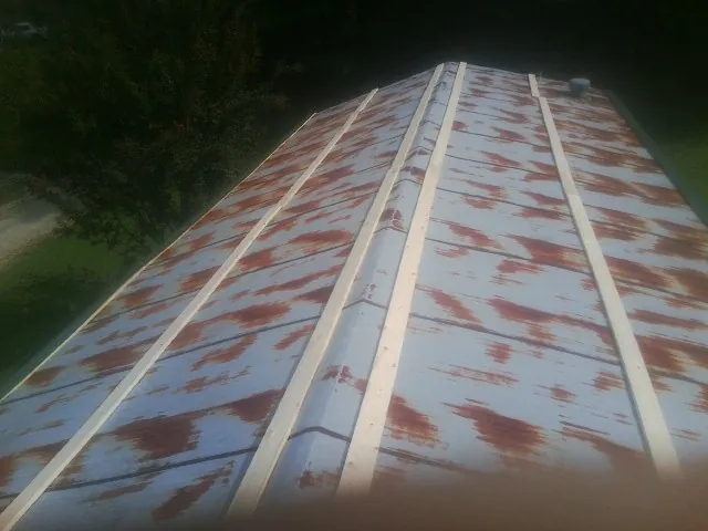 Rusted metal roof panels with new wood purlins before replacement — Storm Damage Roof Repair in Twin Peaks by Roofing Brothers