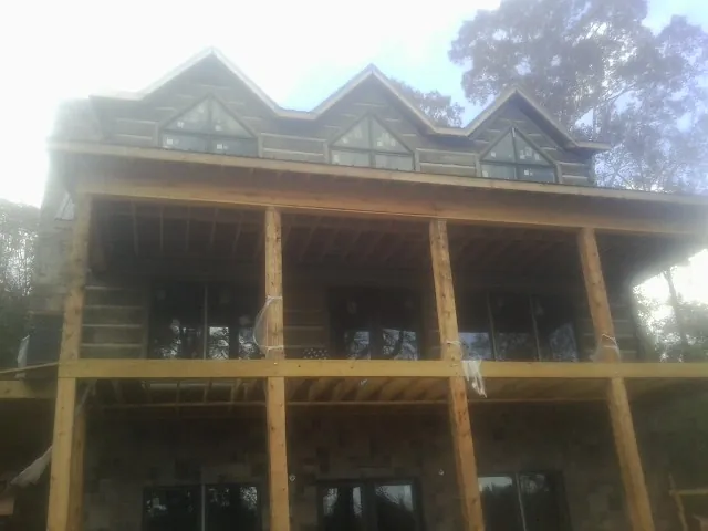 Dormers and porch framing on a large log home under construction — Roof Coating work by our crew in Twin Peaks