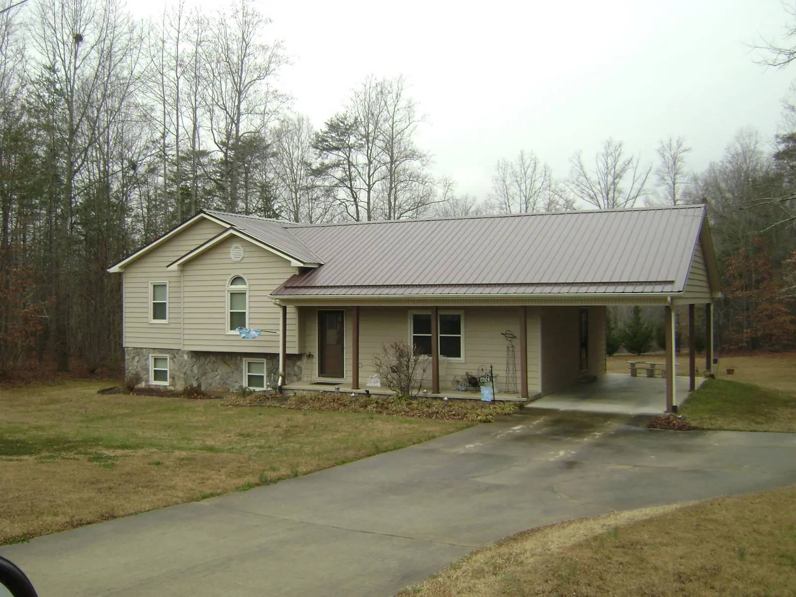 Brown metal roof on a tan split level home with an attached carport in Twin Peaks